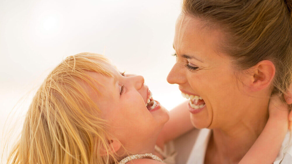 A woman laughing with her child