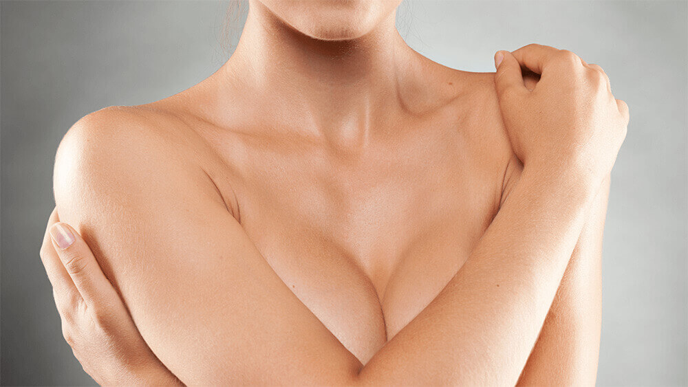 Woman covering her breast with her arms